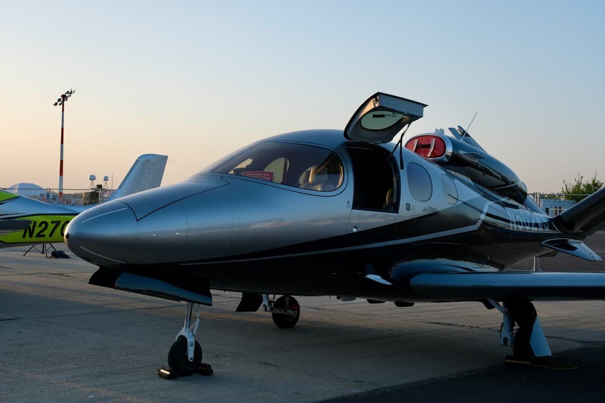 A sleek modern private jet on the tarmac, its polished fuselage catching low light