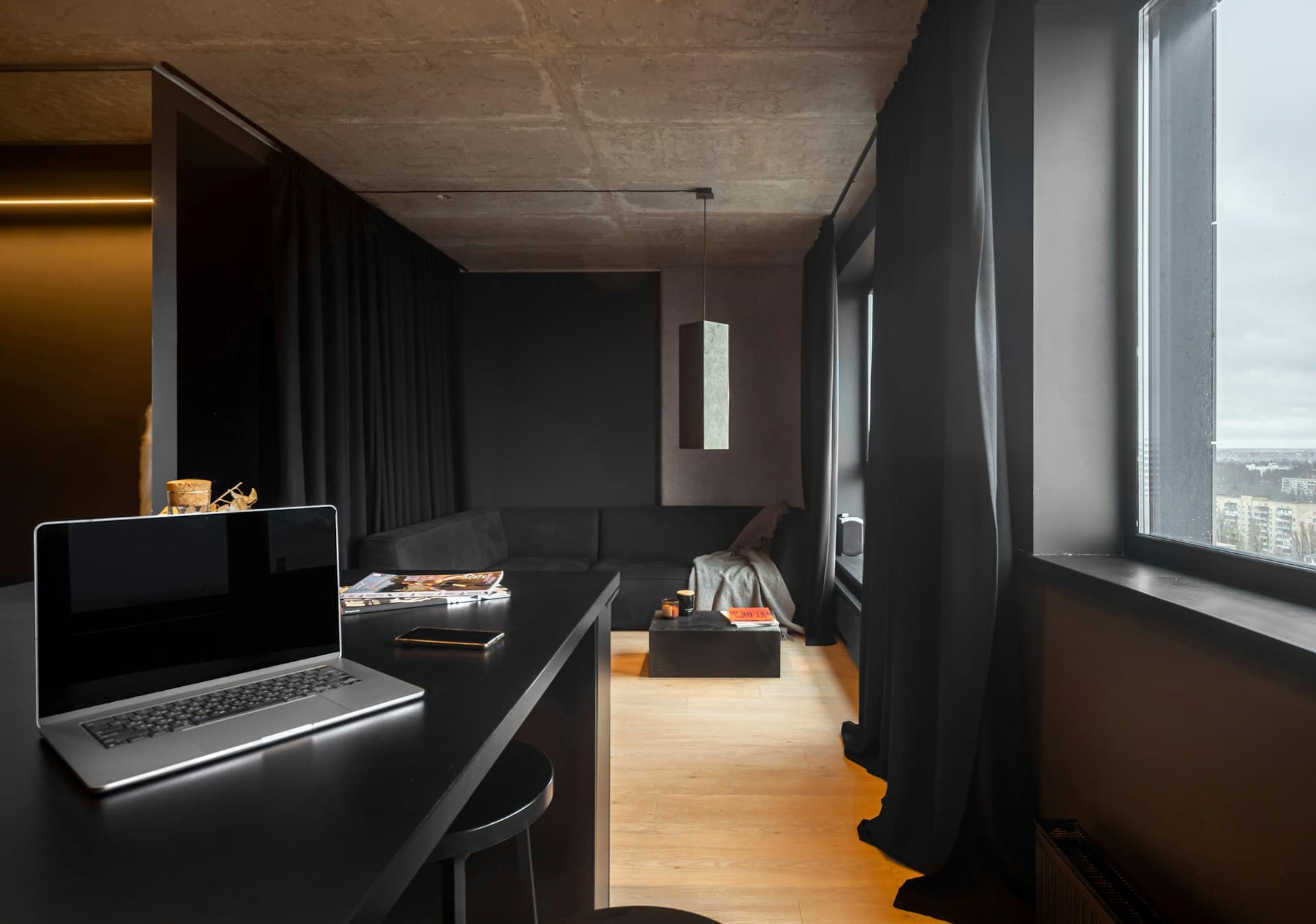 A quiet, refined minimalist interior rendered in dark tones and restrained light