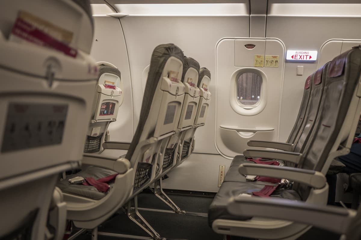 An aircraft cabin lit by soft warm lighting, leather seating receding into shadow