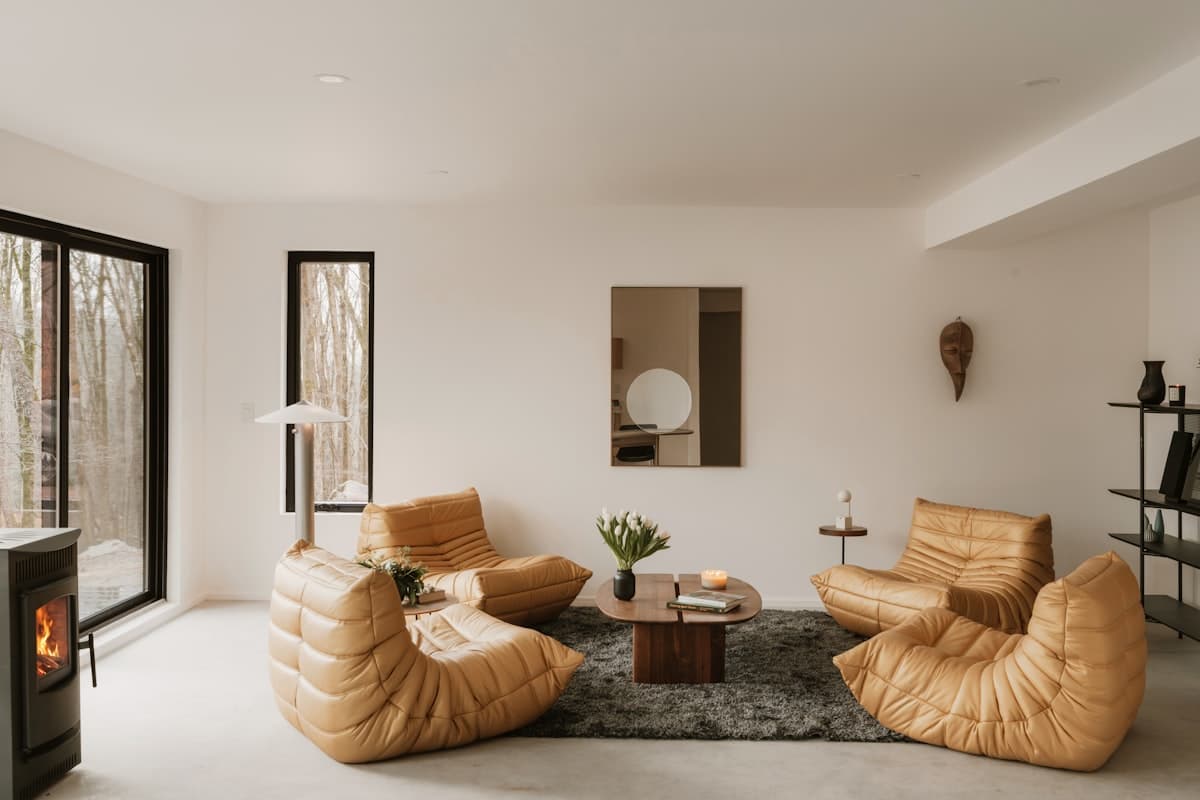 A dark, refined villa living room with leather seating and a fireplace casting warm low light